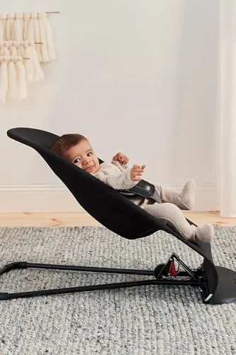 An infant rests in the lowest recline position, weight evenly distributed across the curved frame.