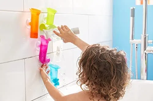 A child explores the suction-mounted Pipes, building custom water channels along the tile wall.