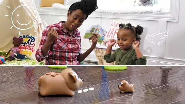 A child directs Ranger across the floor while a parent watches the simple sequence unfold.
