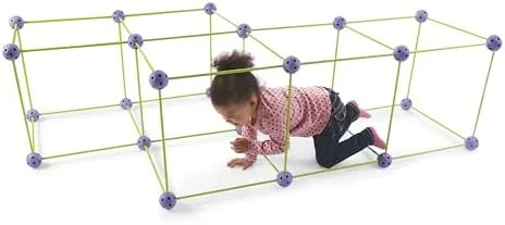 A child crawls through a long rectangular tunnel built from green rods and purple ball connectors.