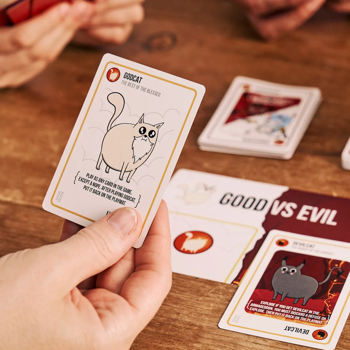 The Godcat card sits at the table mid-game, illustrating the wild-card mechanic added in this editio