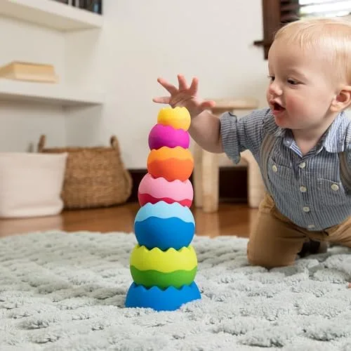 A toddler reaches for a tower mid-wobble, the moment when balance becomes a question worth answering