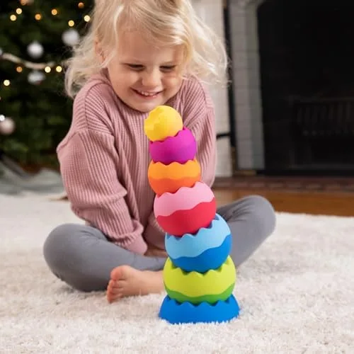 A complete six-piece tower holds itself upright while a delighted child watches the physics settle.