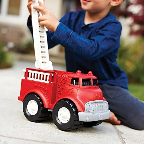 A child manipulates the extending ladder during outdoor play, demonstrating the truck's robust const