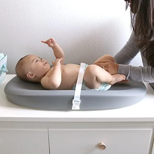 Standard diaper changing on the Grow's cushioned shell, with the safety strap secured.