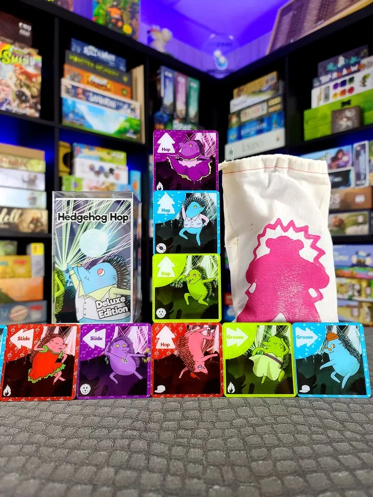 The full Hedgehog Hop spread: box, dance cards, and the cloth dice bag that sets play in motion.