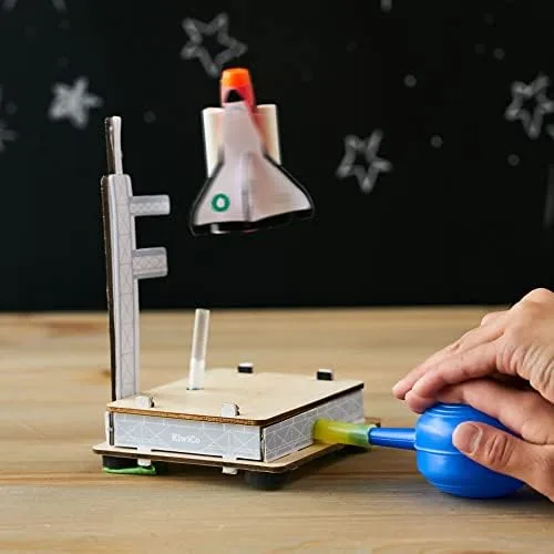 A finished air-pressure rocket launcher fires a foam shuttle as the child squeezes the bulb.