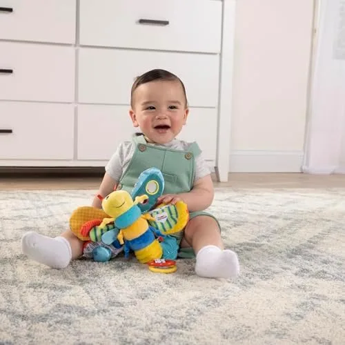 A baby explores Freddie's textured wings in their lap, working multiple sensory channels at once.