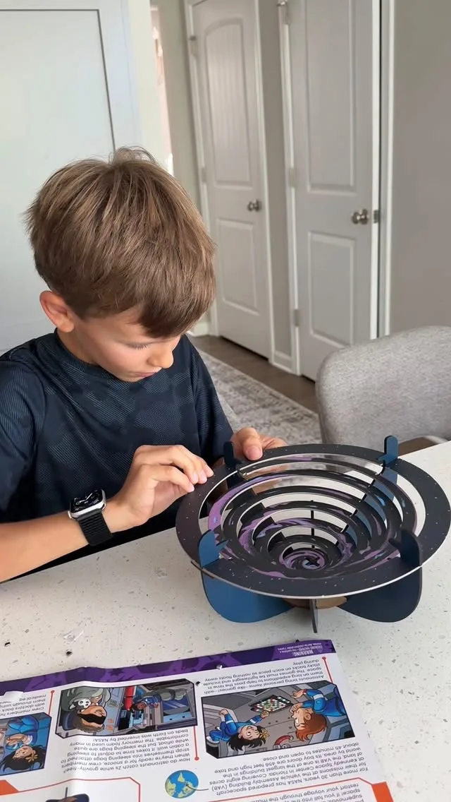 A tester assembles a galaxy-themed build, working alongside the included activity guide.