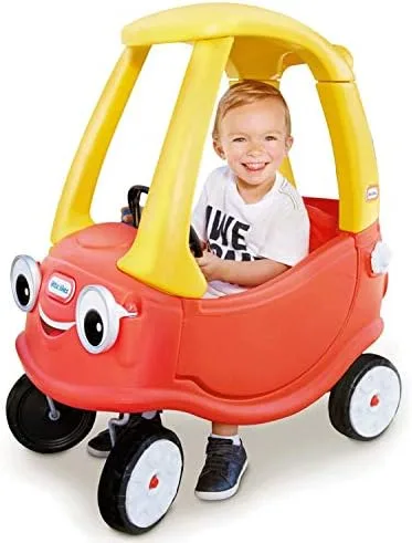 A toddler tester settles into the Cozy Coupe's bench seat, where the open floor lets feet propel the