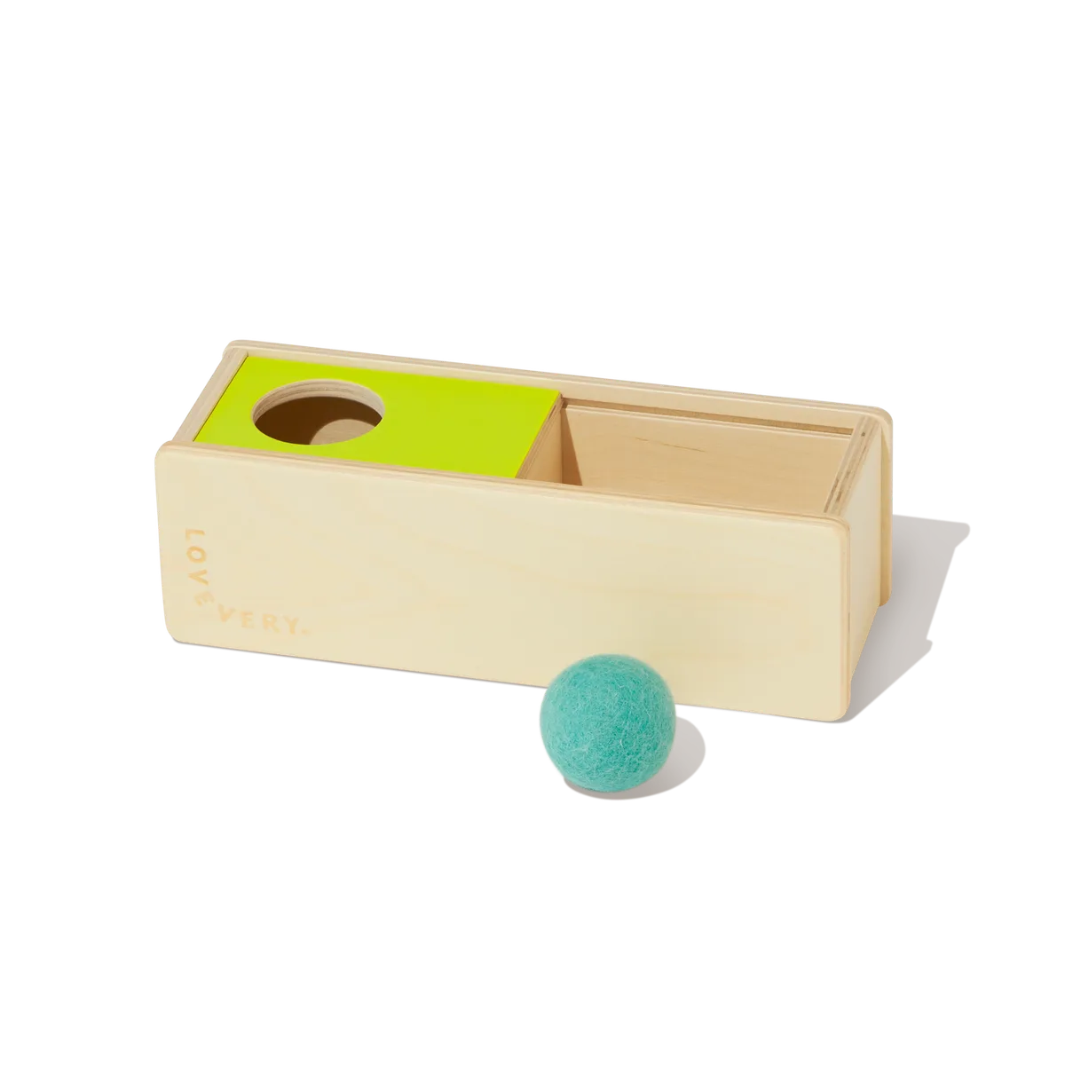 The wooden object permanence box and felt ball demonstrate the slide-and-seek mechanism in repose.