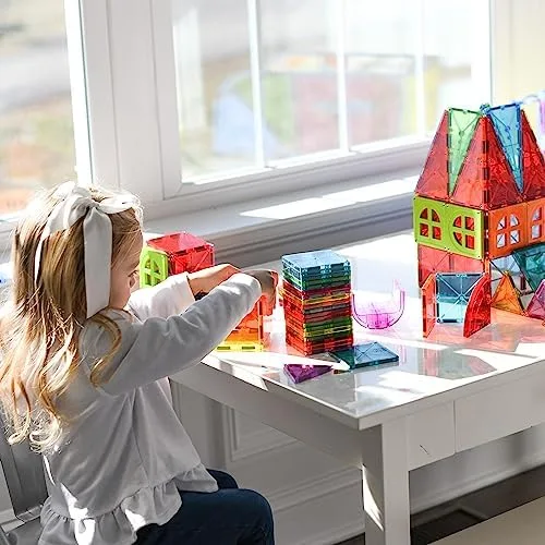 A child constructs a multi-room house at the window — building as set design for an unfolding story.