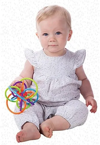 A seated baby explores the Winkel two-handed, rotating the tube structure to find new grip points.