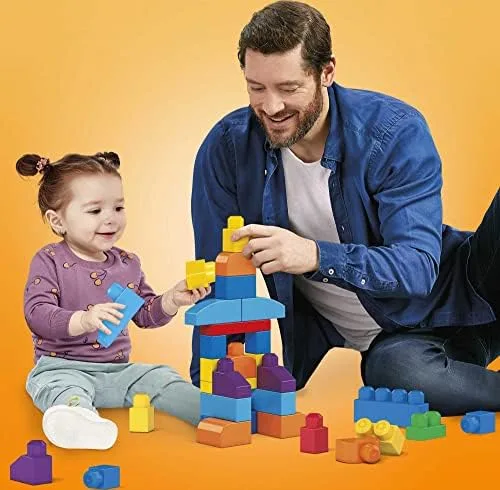 A toddler and parent build together, blocks sized for small hands.