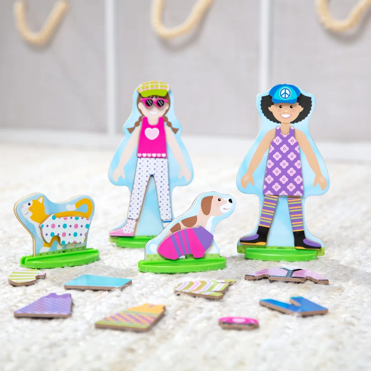Lifestyle scene with figures and loose magnetic pieces — the storage-and-spread reality of how sets 