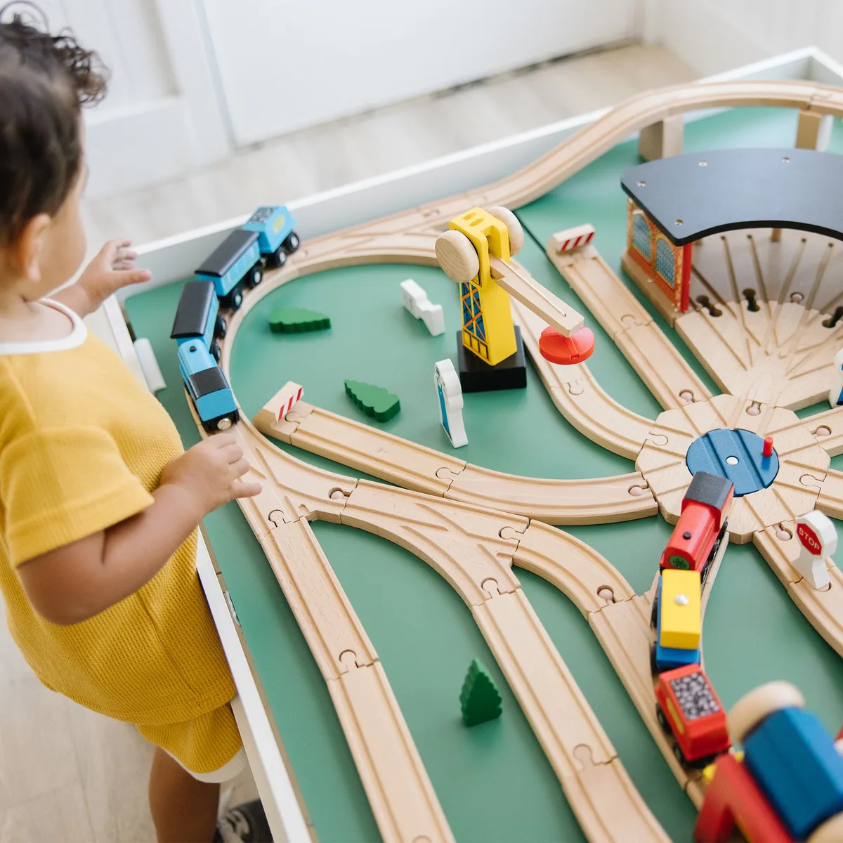 A child engages with the assembled layout — the play pattern that justifies a 130-piece set.