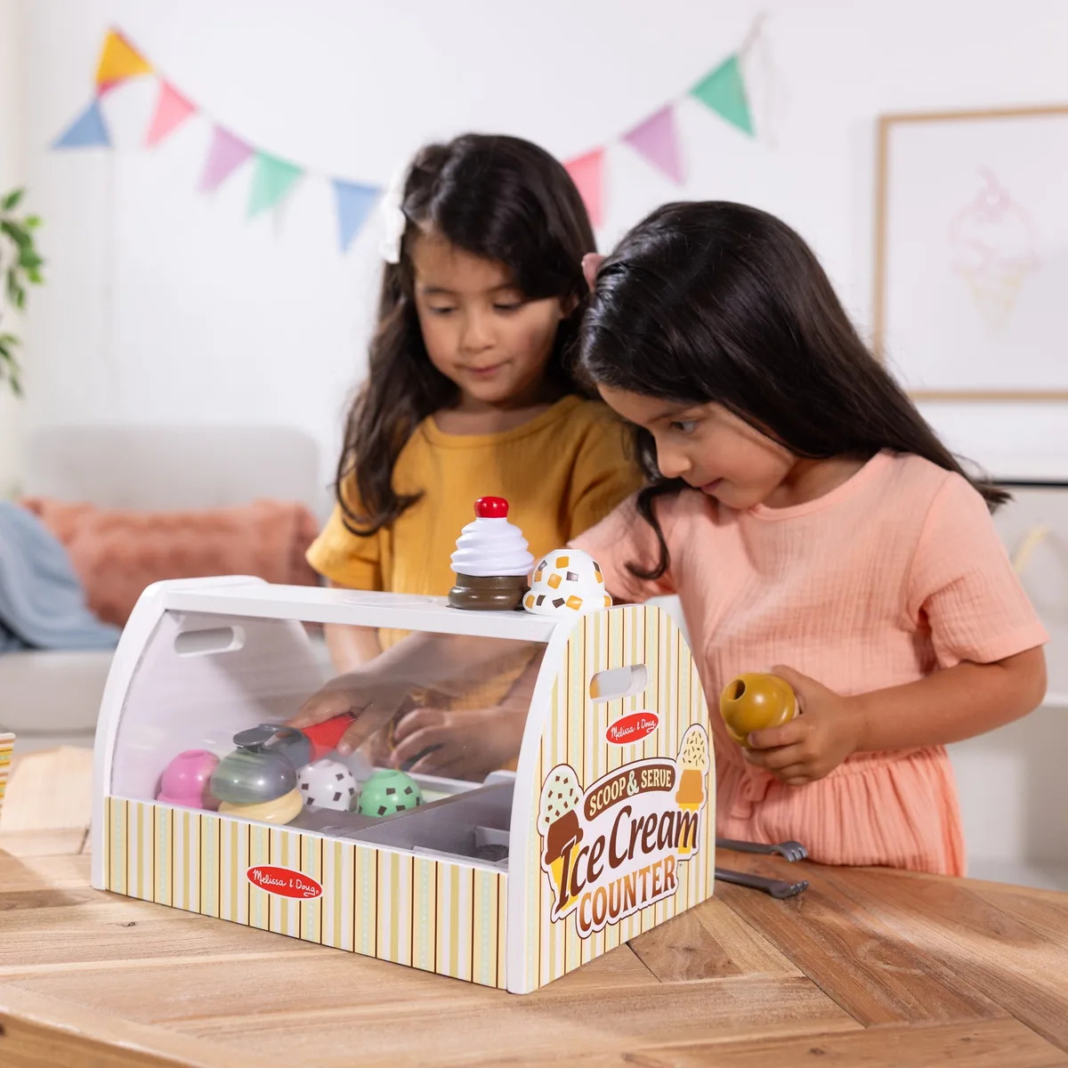 The display case in use: children take turns as customer and shopkeeper, rehearsing turn-taking.