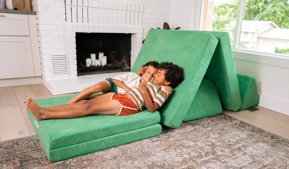 Reconfigured as a lounger — two siblings demonstrate the Mini's modest but real adult-comfort capaci