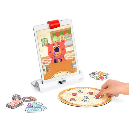 A child makes change with the cardboard coins while the iPad's onscreen customer waits for an answer