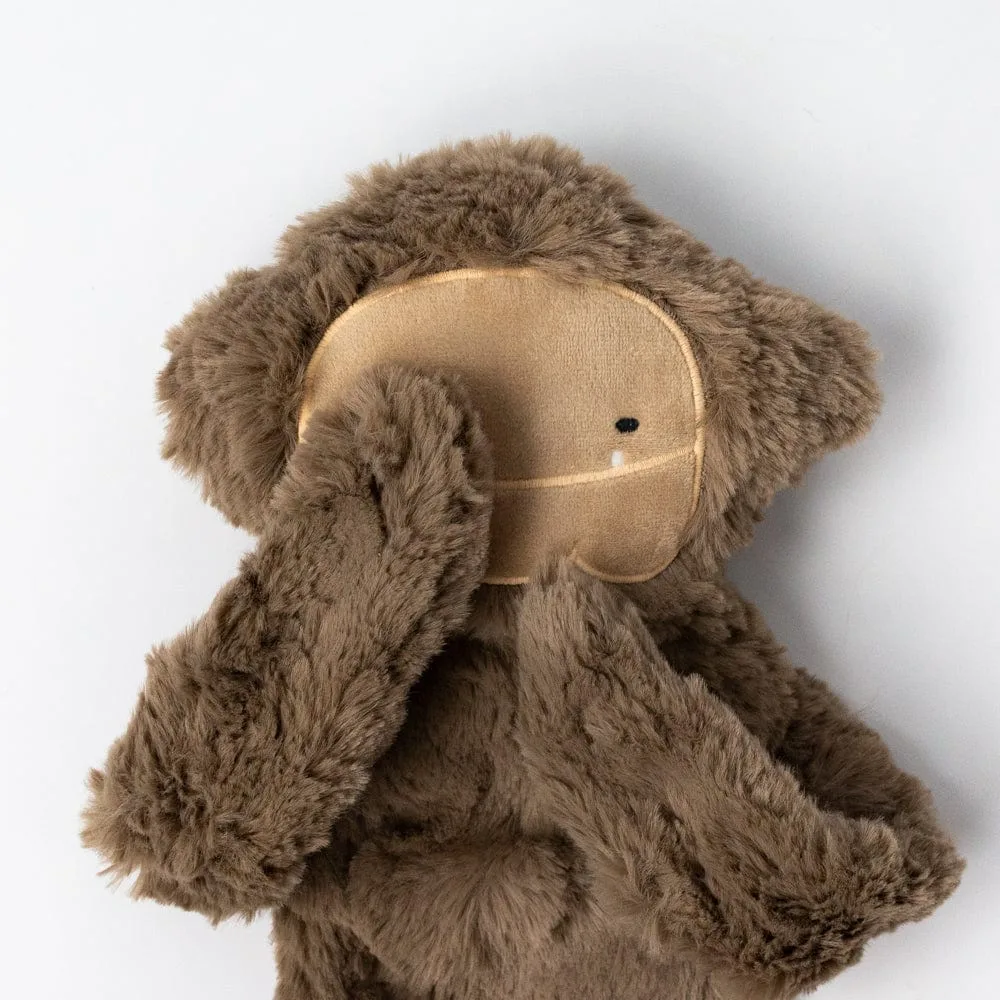 Close detail of the embroidered face — soft contours designed to invite quiet, regulating eye contac