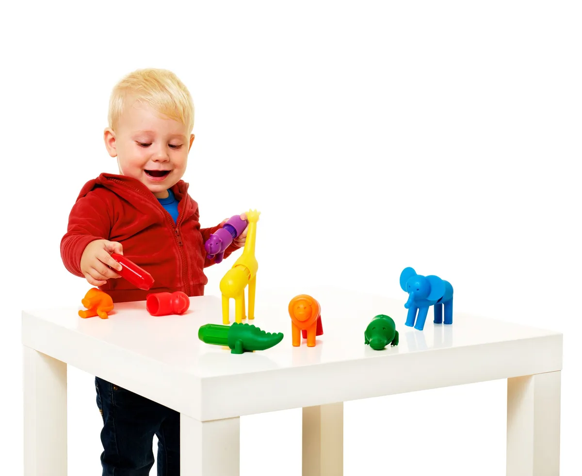 A toddler builds with the oversized animal pieces, demonstrating the satisfying click-fit grip.