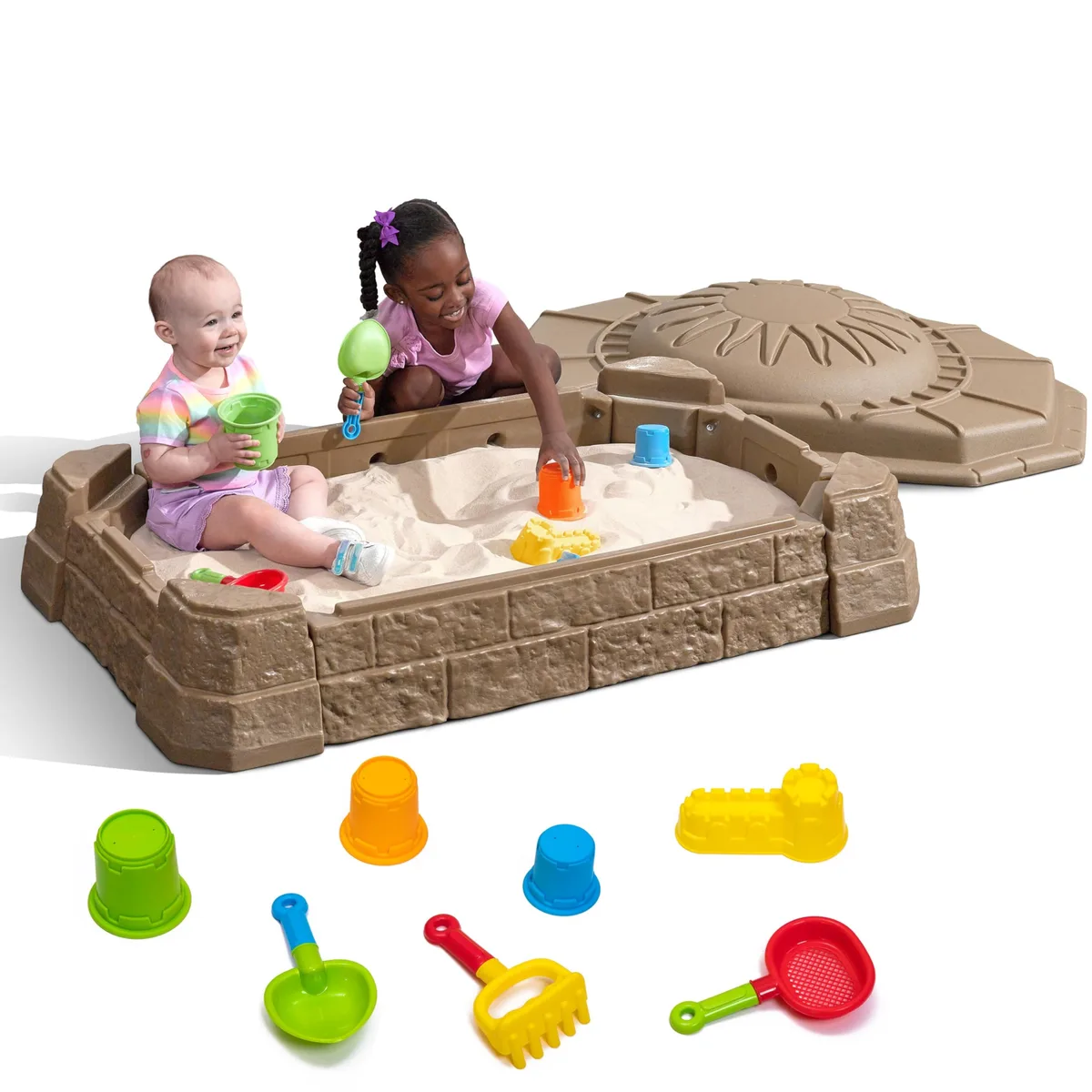 Two children share the molded basin, lid swung open, accessory cups arrayed below.