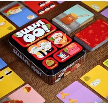 Cards arranged on a wooden table mid-game, the tin centered as a visual anchor.