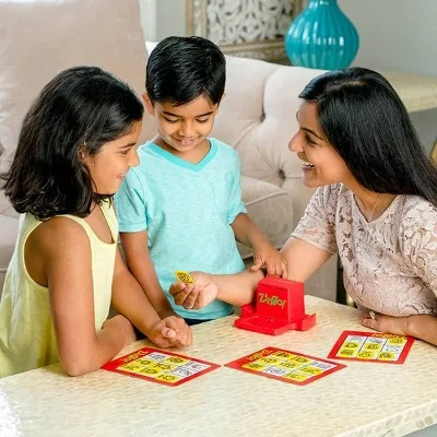 Three players race to claim tiles, the dispenser doing its quiet phonics work between turns.