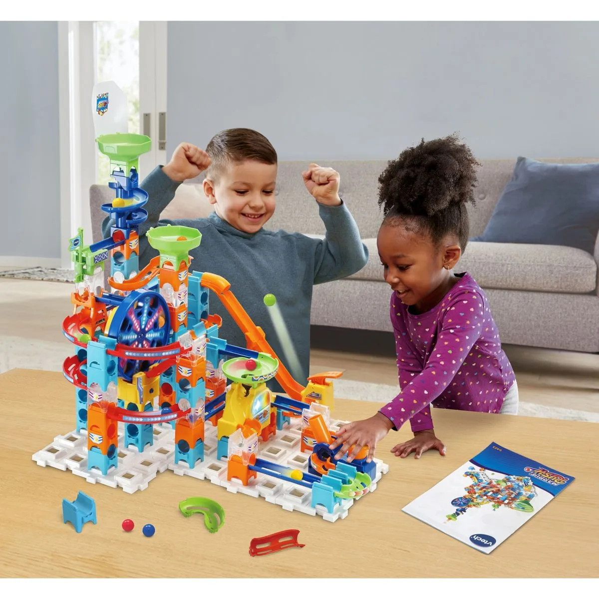 Two children watching a marble travel the track, the moment electronic effects briefly captivated.