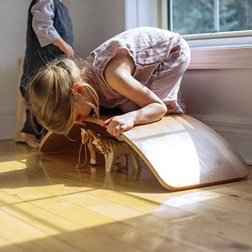 A child improvises a ramp for a wooden horse figurine, demonstrating the board's open-ended play aff