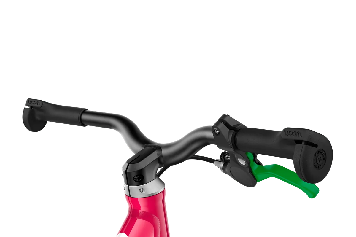 The green-lever hand brake is sized for small fingers, an unusual feature on a balance bike.